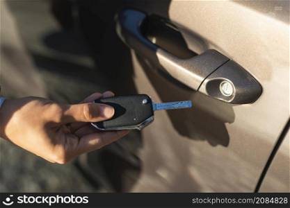 businesswoman using key unlock her car door