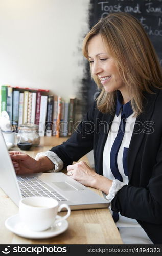 Businesswoman Using Laptop In Cafe