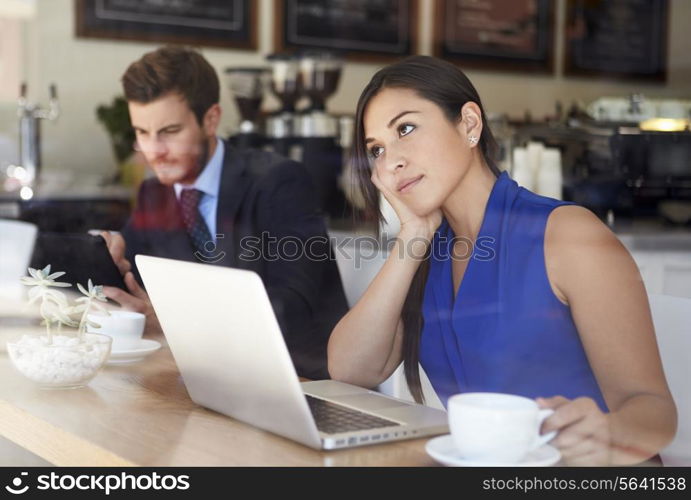 Businesswoman Using Laptop In Coffee Shop