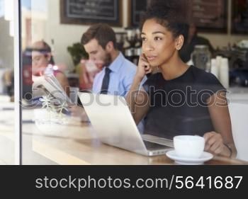 Businesswoman Using Laptop In Coffee Shop