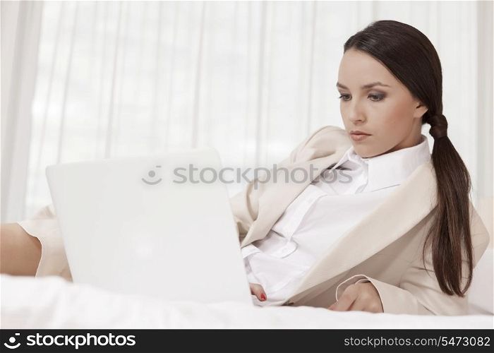 Businesswoman using laptop in hotel room