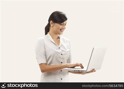 Businesswoman using laptop over white background