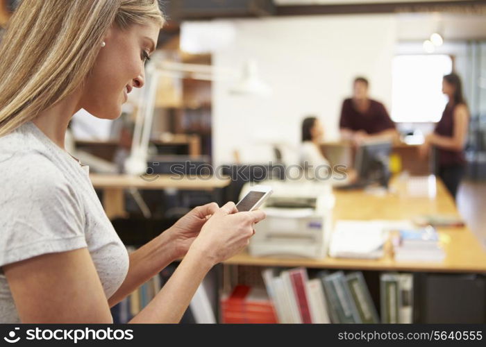 Businesswoman Using Mobile Phone In Modern Office