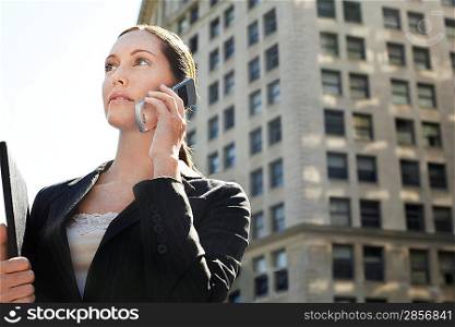 Businesswoman using mobile phone in street