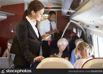 Businesswoman Using Mobile Phone On Busy Commuter Train