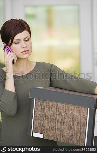 Businesswoman Using Mobile Phone with Moving Box