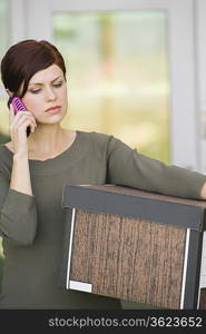 Businesswoman Using Mobile Phone with Moving Box