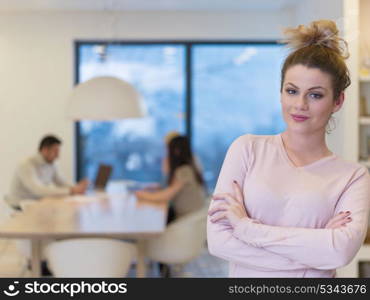 Businesswoman using tablet with coworkers in backgorund having meeting