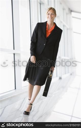 Businesswoman walking in corridor smiling