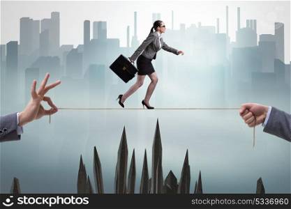 Businesswoman walking on tight rope in business concept