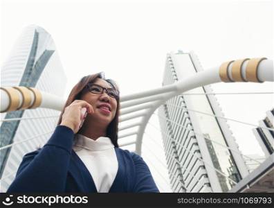 businesswoman walking outdoor and talking on mobile phone