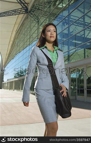 Businesswoman walking past office building