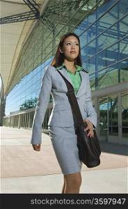 Businesswoman walking past office building