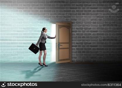 Businesswoman walking towards open door