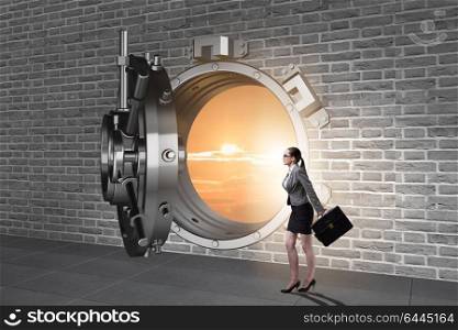 Businesswoman walking towards open vault door