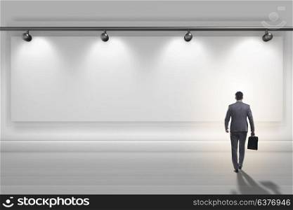Businesswoman walking towards the wall lit with spotlights