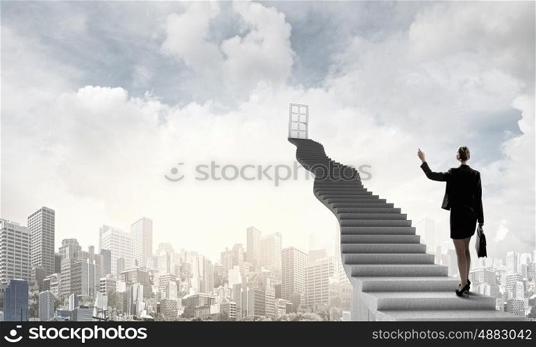 Businesswoman walking up staircase to door in sky. Way to success