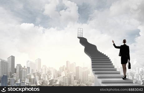 Businesswoman walking up staircase to door in sky. Way to success