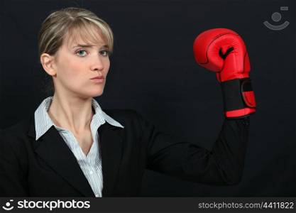 Businesswoman wearing a boxing glove