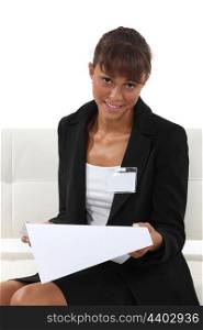 Businesswoman wearing an ID badge and reading a document