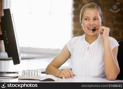 Businesswoman wearing headset in office smiling