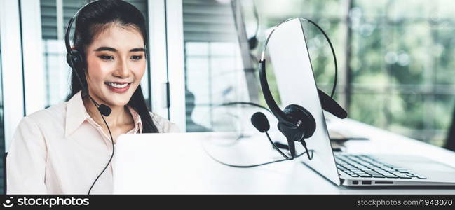 Businesswoman wearing headset working actively in office . Call center, telemarketing, customer support agent provide service on telephone video conference call.. C1