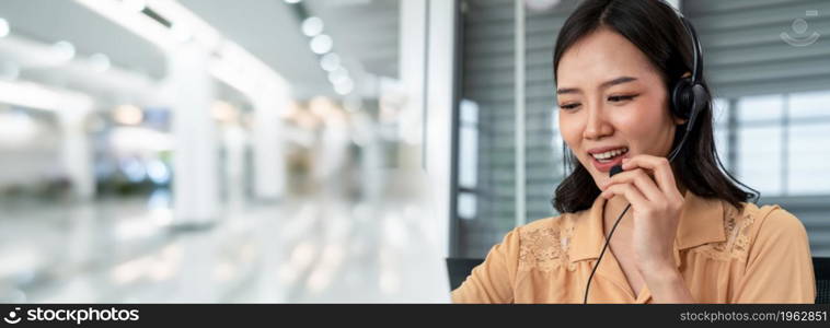 Businesswoman wearing headset working actively in office . Call center, telemarketing, customer support agent provide service on telephone video conference call.. C2