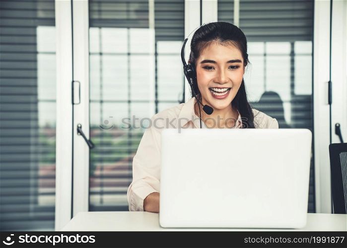 Businesswoman wearing headset working actively in office . Call center, telemarketing, customer support agent provide service on telephone video conference call.. Businesswoman wearing headset working actively in office