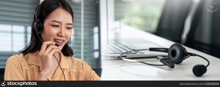 Businesswoman wearing headset working actively in office . Call center, telemarketing, customer support agent provide service on telephone video conference call.. Businesswoman wearing headset working actively in office