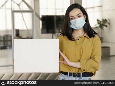 businesswoman wearing medical mask work while holding blank card