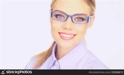 Businesswoman with a beautiful smile wearing trendy modern glasses, closeup head and shoulders studio portrait