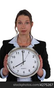 Businesswoman with a clock showing 8am