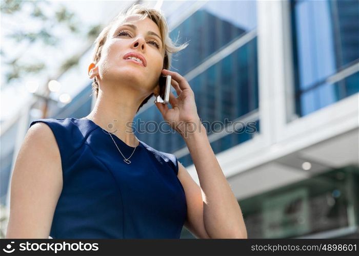 Businesswoman with a phone in a city. Hello there from business lady