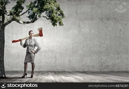 Businesswoman with axe representing problem of deforestation. Stop cutting trees