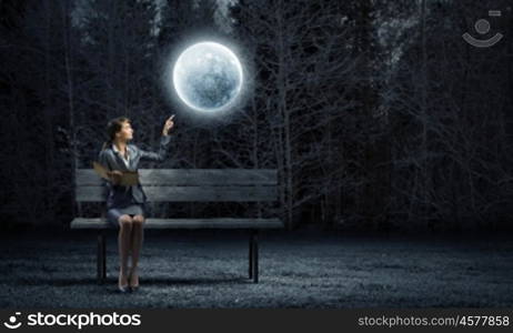 Businesswoman with book. Young businesswoman sitting on bench with book in hands