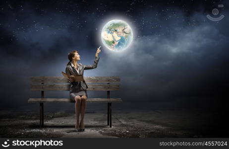 Businesswoman with book. Young smiling businesswoman sitting on bench with book in hands. Elements of this image are furnished by NASA