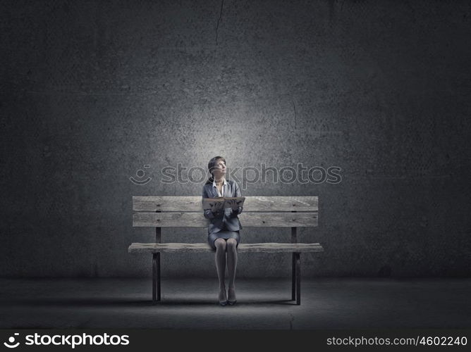 Businesswoman with book. Young smiling businesswoman sitting on bench with book in hands