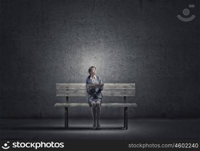 Businesswoman with book. Young smiling businesswoman sitting on bench with book in hands