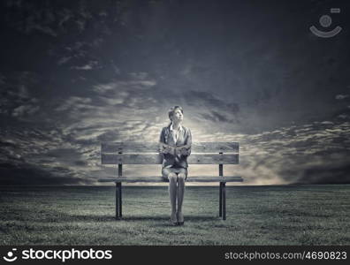 Businesswoman with book. Young smiling businesswoman sitting on bench with book in hands