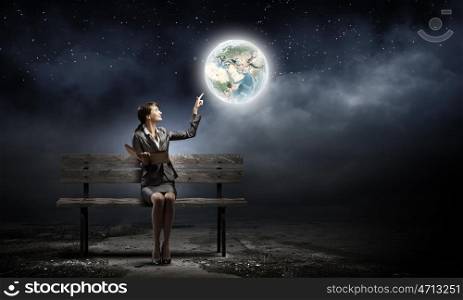 Businesswoman with book. Young smiling businesswoman sitting on bench with book in hands. Elements of this image are furnished by NASA