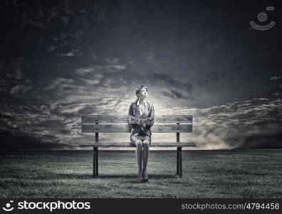 Businesswoman with book. Young smiling businesswoman sitting on bench with book in hands