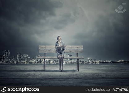 Businesswoman with book. Young smiling businesswoman sitting on bench with book in hands