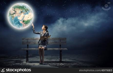 Businesswoman with book. Young smiling businesswoman sitting on bench with book in hands. Elements of this image are furnished by NASA