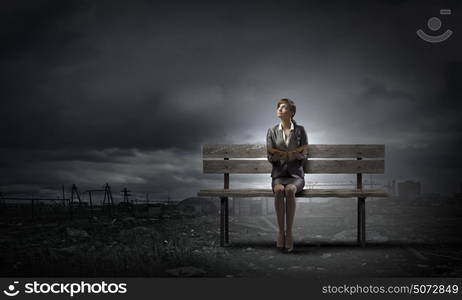 Businesswoman with book. Young smiling businesswoman sitting on bench with book in hands