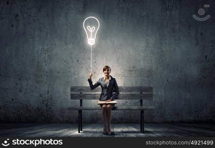 Businesswoman with book. Young smiling businesswoman sitting on bench with book on knees