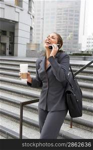 Businesswoman with Cell Phone and Coffee Cup