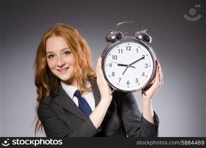 Businesswoman with clock being late for her deliverables