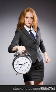 Businesswoman with clock being late for her deliverables