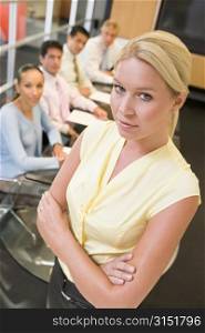 Businesswoman with four businesspeople at boardroom table in background