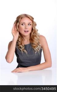 Businesswoman with hand on ear to listen